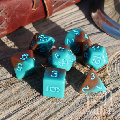 Set of teal and brown shiny polyhedral dice on a wooden surface