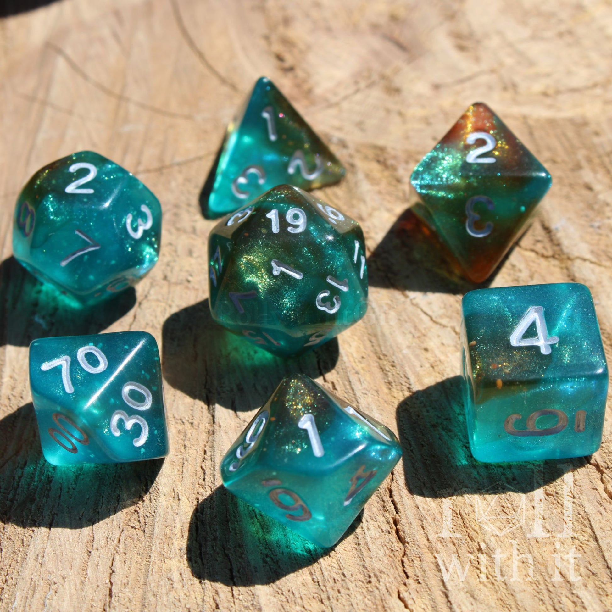 Set of 7 teal blue polyhedral TTRPG roleplaying dice on a wooden surface