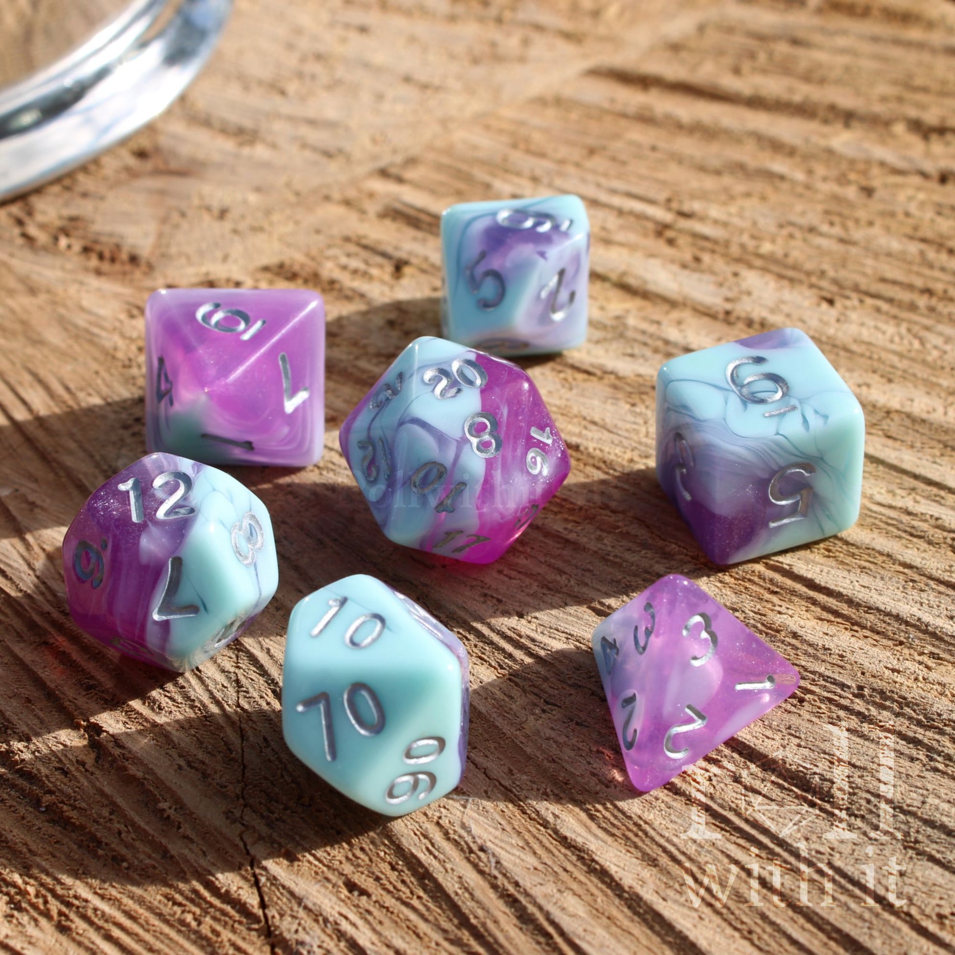 Set of colorful blue purple silver letters polyhedral dice on a wooden surface