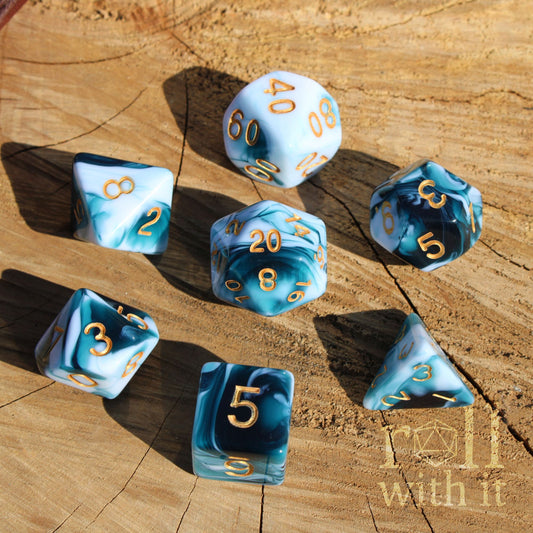 Set of blue and white mixed marble polyhedral dice with gold numbers on a wooden surface.