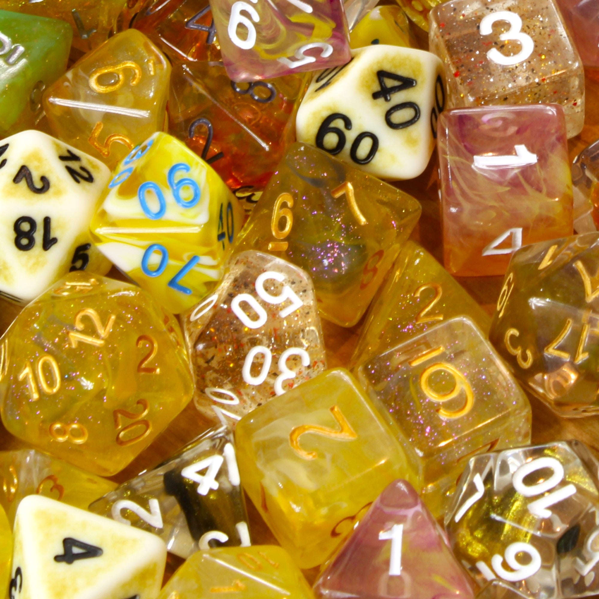 Assorted colourful yellow polyhedral roleplaying dice with various numbers in a pile